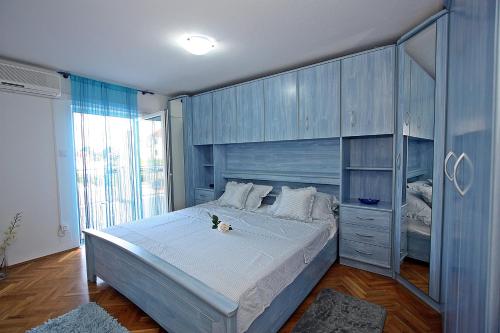 1 dormitorio con 1 cama grande y armarios azules en Apartments with WiFi Supetar, Brac - 5665, en Supetar