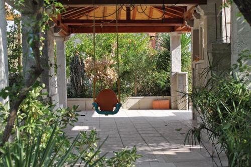 a swing in the middle of a courtyard at Apartments by the sea Sumartin, Brac - 5615 in Sumartin