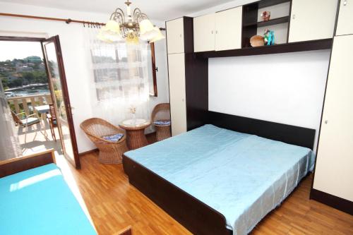 a small bedroom with a bed and a balcony at Apartments by the sea Sumartin, Brac - 5615 in Sumartin