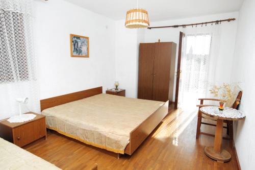ein Schlafzimmer mit einem großen Bett und einem Tisch in der Unterkunft Apartments by the sea Sumartin, Brac - 5615 in Sumartin