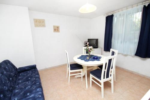 a dining room with a white table and chairs at Apartments by the sea Sumartin, Brac - 5615 in Sumartin