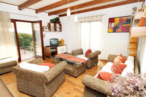 a living room with wicker chairs and a television at Apartments by the sea Klenovica, Novi Vinodolski - 5580 in Klenovica