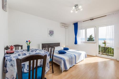 ein Esszimmer mit einem Tisch und ein Zimmer mit einem Fenster in der Unterkunft Apartments by the sea Klenovica, Novi Vinodolski - 5575 in Klenovica