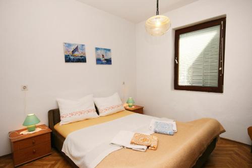 1 dormitorio con 1 cama, ventana y 2 toallas en Apartments with a parking space Jadranovo, Crikvenica - 5533, en Jadranovo