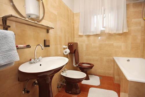 a bathroom with a sink and a toilet at Apartments with a parking space Postira, Brac - 5618 in Postira