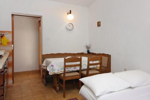 a room with a table and chairs and a clock on the wall at Apartments with parking space Supetar, Brac - 5653 in Supetar