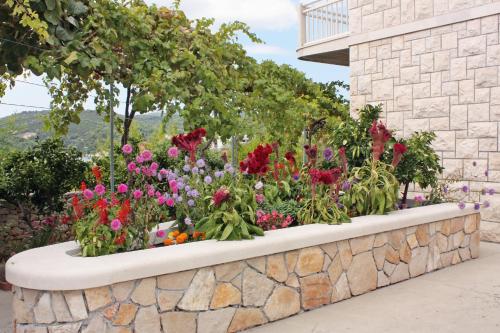 a garden of flowers in a stone wall at Apartments by the sea Sumartin, Brac - 5620 in Sumartin