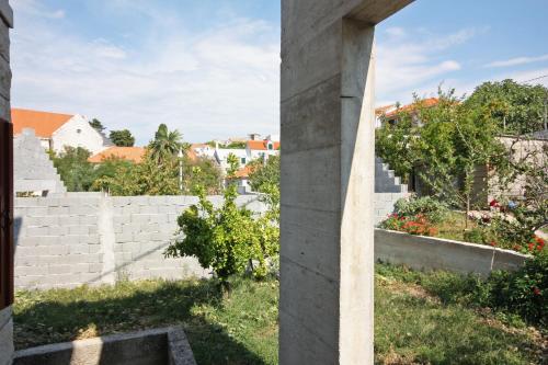 a view of a brick wall and a garden at Apartments by the sea Sumartin, Brac - 5620 in Sumartin