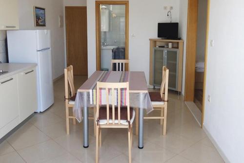 a kitchen with a table with chairs and a refrigerator at Apartments by the sea Sumartin, Brac - 5620 in Sumartin