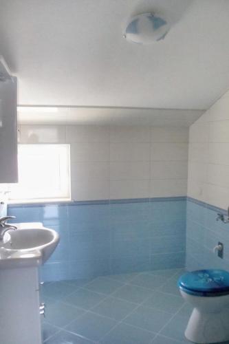 a blue and white bathroom with a toilet and a sink at Apartments by the sea Sumartin, Brac - 5620 in Sumartin