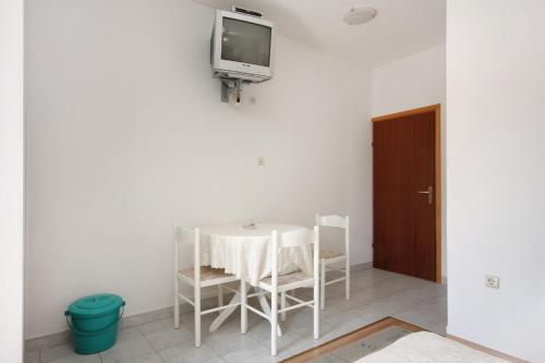 a room with a table and a tv on a wall at Apartments by the sea Sumartin, Brac - 5620 in Sumartin