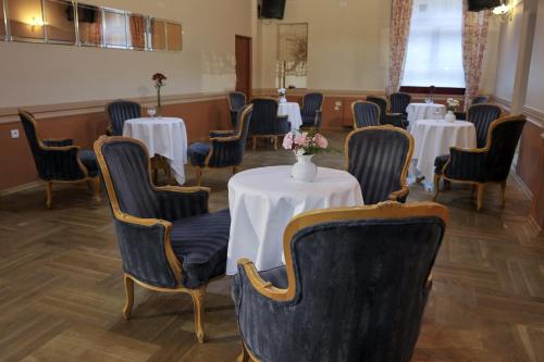 a room with tables and chairs with flowers on them at Hotel Mir-Jan SPA in Lądek-Zdrój