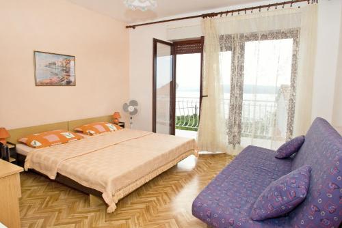 a bedroom with a bed and a couch and a window at Apartments with a parking space Dramalj, Crikvenica - 5576 in Dramalj