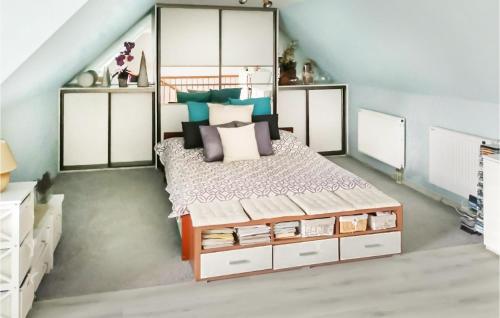 a bedroom with a large bed with white cabinets at Nice Home In Nowe Warpno With Wifi in Nowe Warpno
