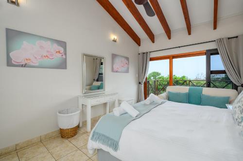 a bedroom with a white bed and a mirror at San Lameer Villa - 14403 - 4 Bedroom Deluxe - 8 pax - San Lameer Rental Agency in Southbroom