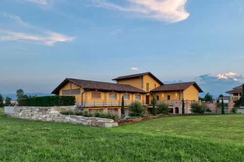 a large yellow house on a green field at I Boschetti in Magliano Alpi