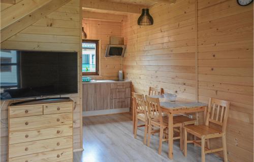 a dining room and kitchen in a log cabin at Beautiful Home In Grzybowo With 2 Bedrooms And Wifi in Grzybowo