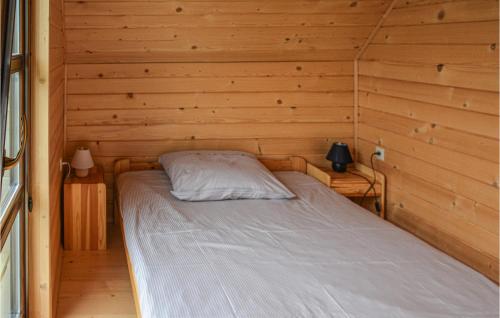 1 cama en una cabaña con paredes de madera en Cozy Home In Grzybowo With Kitchen en Grzybowo