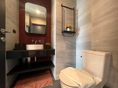 a bathroom with a white toilet and a sink at Downtown Chic Condo Rooftop Pool #EN797 in Pattaya Central