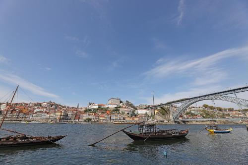um grupo de barcos na água perto de uma ponte em FLH Gaia Homey Studio em Vila Nova de Gaia