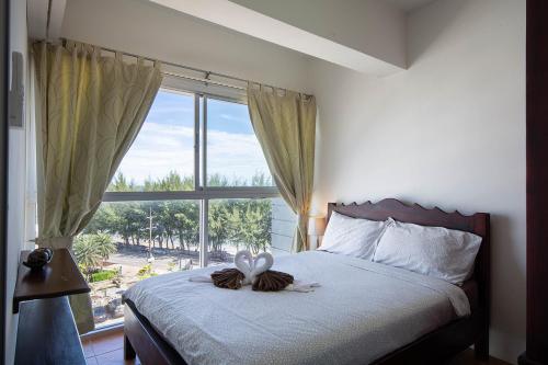 um quarto com uma cama e uma janela grande em Avatara A condominium B61 with sea view em Mae Pim