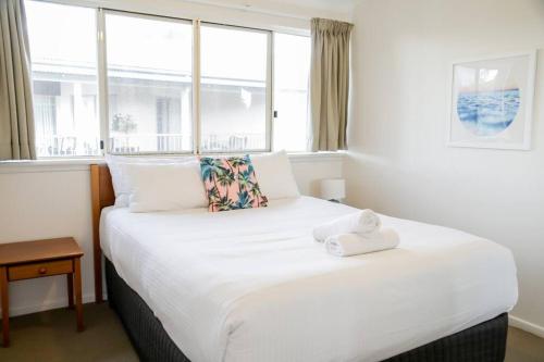 En eller flere senge i et værelse på 15 Whale Watch Resort + Beach Front + Ducted Air Con + 3 Bed + 2 Bath