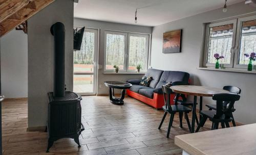 a living room with a couch and a wood stove at Kaszubska Zagroda in Lipuska Huta