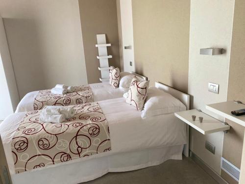 a small bedroom with a white bed and a table at Appartamento I Boschetti in Magliano Alpi