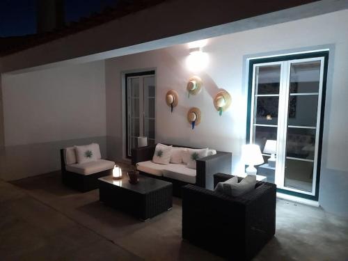 a living room with couches and tables and a window at Moradia de férias Casa do Chorão - Montargil in Montargil