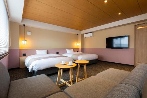 Habitación de hotel con 2 camas y sofá en Rinn Gion Yasaka en Kioto