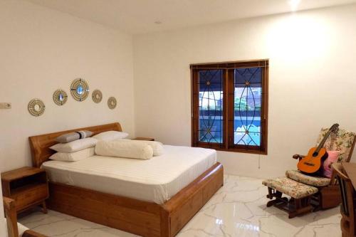 Un dormitorio con una cama y una guitarra. en Villa Bale Damai Denpasar, en Seminyak