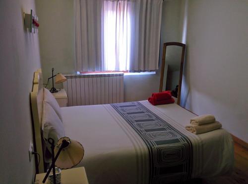 a bedroom with a large white bed with a window at Cal Puro in Castellnou de Seana
