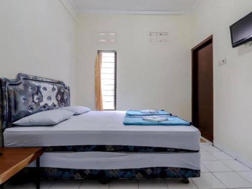 ein Schlafzimmer mit einem Bett mit einer blauen Decke in der Unterkunft HOTEL KANA KALIURANG in Sleman