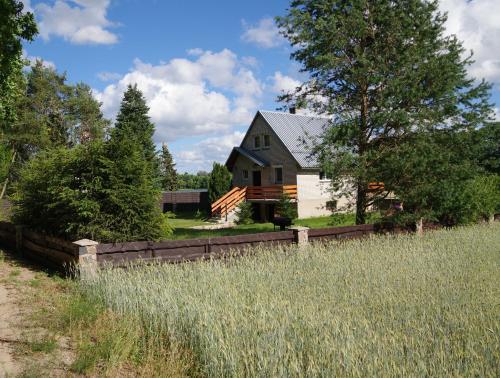 a black and white house with a fence at Kaszubska Zagroda in Lipuska Huta