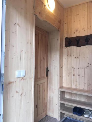 a wooden room with a door and a shelf at Chalupa Magistrála in Horní Blatná