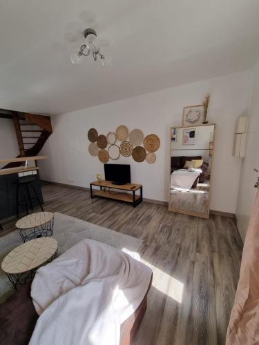 a living room with a bed and a mirror at Duplex 40m2 cocooning cœur de ville avec parking in Neauphle-le-Château