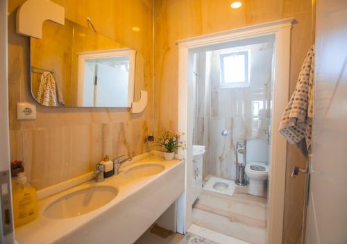 ein Badezimmer mit zwei Waschbecken und einer Toilette und einem Spiegel in der Unterkunft Öztürk Farm House in Samsun