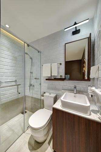 a bathroom with a toilet and a sink and a shower at Aerotel Cebu in Mactan