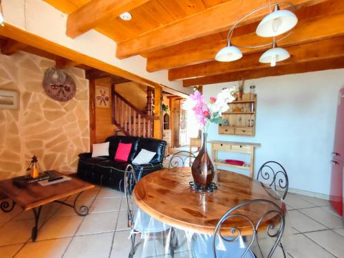 a living room with a table with a vase of flowers on it at La Belle Escale in Gap