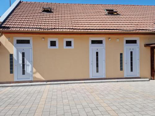 a small house with blue doors and a tile roof at Belvárosi Pihenőház in Békéscsaba