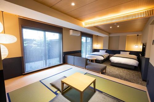 a hotel room with two beds and a living room at Rinn Gion Yasaka in Kyoto