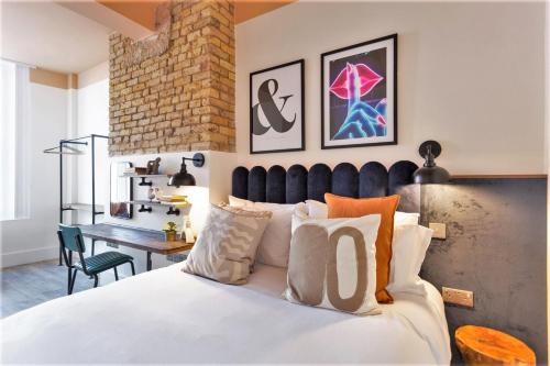 a bedroom with a large white bed and a desk at Your Apartment I Brixton in London