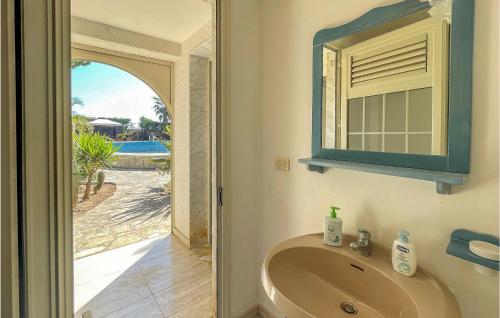 ein Bad mit einem Waschbecken und einem Spiegel in der Unterkunft Gorgeous Apartment In Frigole With Kitchen in Frigole