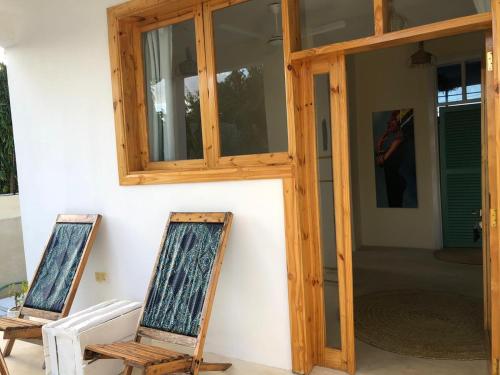 two chairs sitting in front of a door at Zanzibar Tropical Sunset Boutique Hotel - Adults Only in Kiwengwa