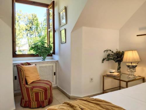 - une chambre avec un lit, une chaise et une fenêtre dans l'établissement La Casa de San Fernando con vistas a los Reales Alcázares, à Séville