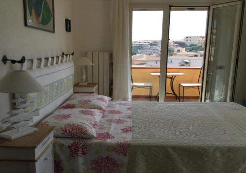 a bedroom with a bed and a view of a balcony at Villa le Bougainvillea in La Maddalena