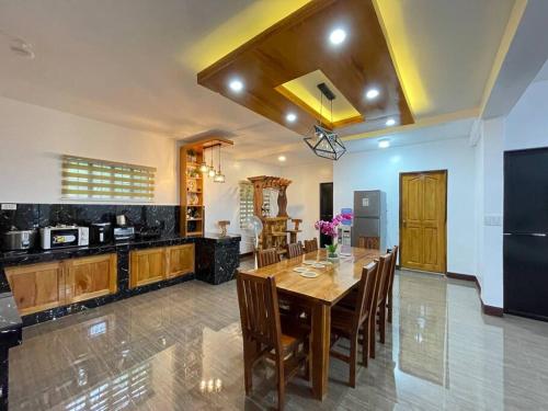 a large kitchen with a wooden table and chairs at Tagaytay Transient House, 4 bedrooms, billiard in Indang