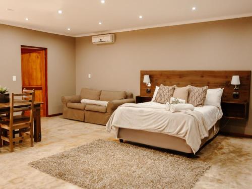 a bedroom with a bed and a couch and a table at 37 On Anderson in Pretoria