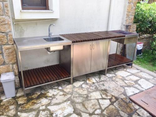 an outdoor kitchen with a sink on a stone patio at Aestas in Neos Marmaras