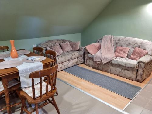 a living room with two couches and a table at Belvárosi Pihenőház in Békéscsaba